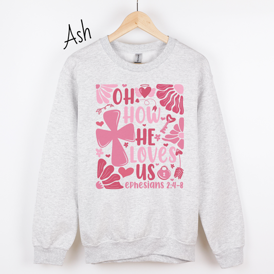 "Oh how He loves us Ephesians 2:4-8" written in various shades of pink with florals and a cross on an ash colored sweatshirt.