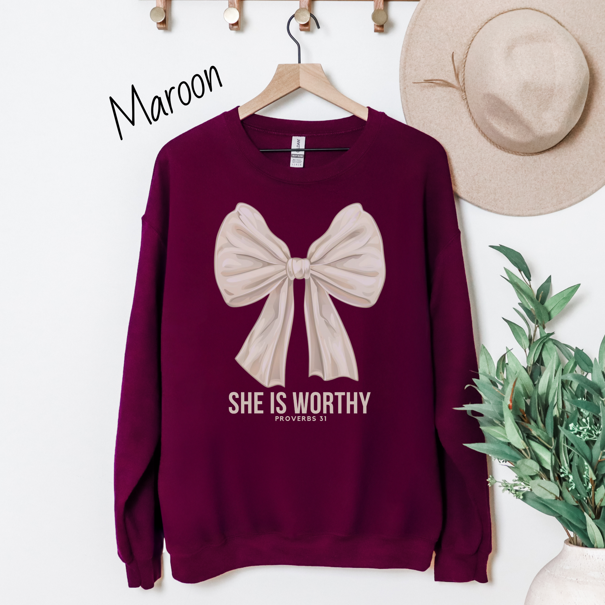 Large white bow with the words "She is Worthy Proverbs 31" on a maroon sweatshirt.